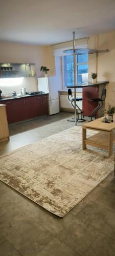 un ampio soggiorno con un tavolo e un tappeto di Masčio apartamentai a Telšiai