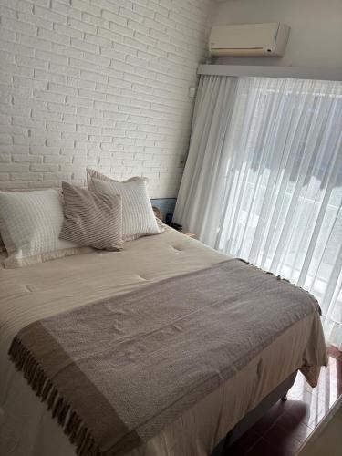 a bedroom with a large bed with a window at Casa en Complejo Sierra Alta in Punta del Este