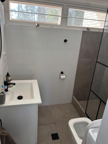 a white bathroom with a sink and a shower at Casa en Complejo Sierra Alta in Punta del Este