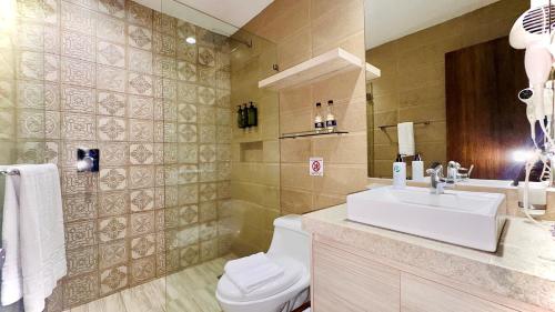 a bathroom with a white sink and a toilet at Hotel Puerto Pacifico Guayaquil Airport in Guayaquil