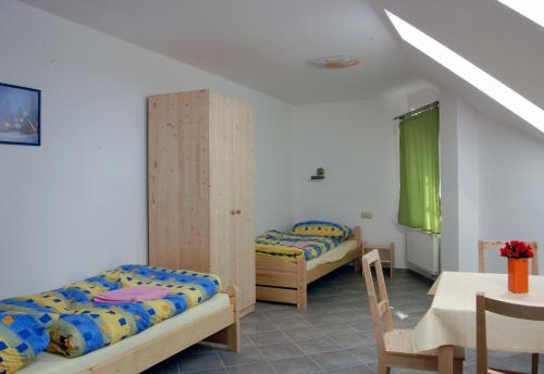 1 Schlafzimmer mit 2 Betten, einem Tisch, einem Tisch und Stühlen in der Unterkunft Pension Camp Prager in Prag