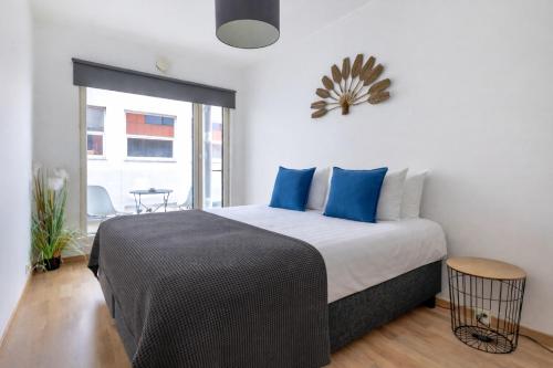 a bedroom with a king sized bed with blue pillows at City center apartment with free parking and sauna in Tallinn