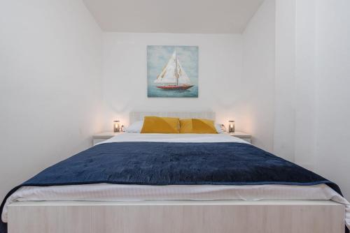 a bedroom with a bed with a sailboat on the wall at Holiday home Atrium in Nin