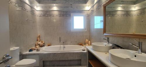 a bathroom with two sinks and a large mirror at Villa Santa Mavra in Glinado Naxos