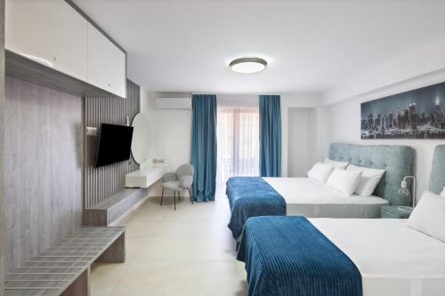 a hotel room with two beds and a tv at Hotel Tommy in Budva
