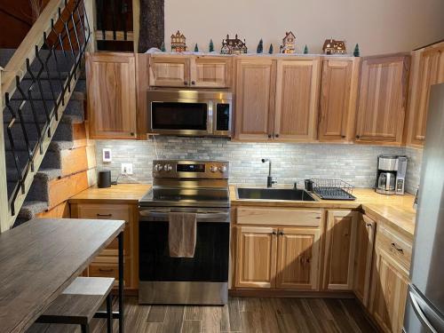a kitchen with wooden cabinets and a stove top oven at The Treehouse at 11 Gables - Center of Ludlow Village near Shopping and Restaurants in Ludlow