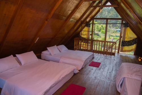 a bedroom with two beds in a wooden room at Cloud Nest Cabana in Ohiya