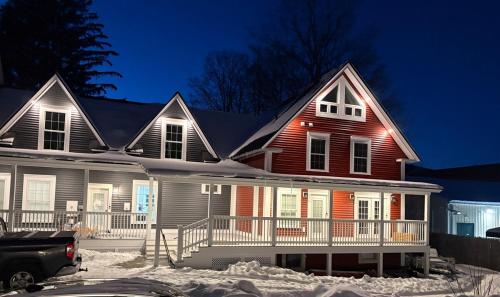 a house in the snow at night at The Treehouse at 11 Gables - Center of Ludlow Village near Shopping and Restaurants in Ludlow