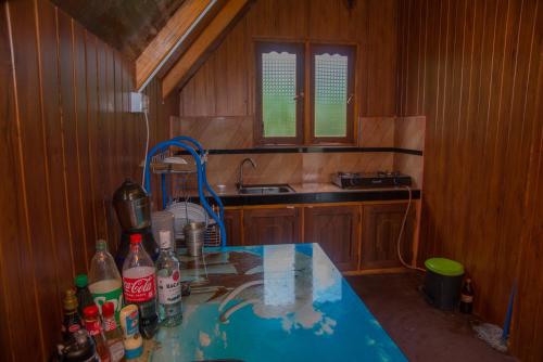 a kitchen with a sink and a table with bottles on it at Cloud Nest Cabana in Ohiya