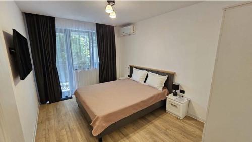 a small bedroom with a bed and a window at Copou Luxury Suites in Vaslui