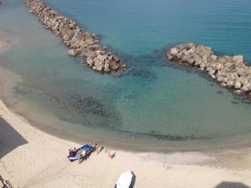 a group of people on a beach near the water at Marina Holiday Home in Pizzo