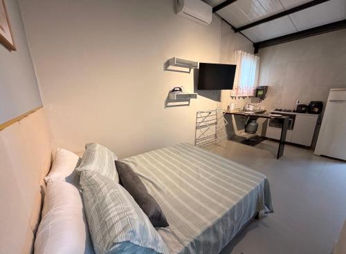 a bedroom with a bed and a desk in it at Flat 02 - Ar condicionado ao lado do Camaru, próximo ao UMC e shopping in Uberlândia