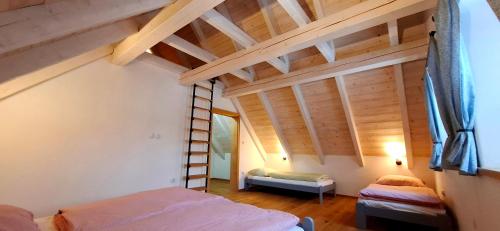 a attic room with two beds and a ladder at Chalupa Louka in Slavonice