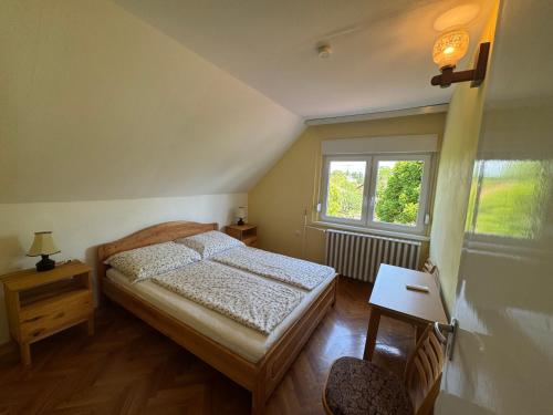 a bedroom with a bed and a window at Tiszafa Apartman in Csopak