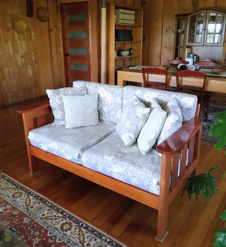 a couch with pillows on it in a living room at Hostal los arrayanes in Puerto Carmen