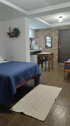 a bedroom with a bed and a kitchen with a table at Central Apartment 2 in Ouro Preto