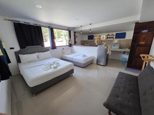 a living room with two beds and a kitchen at Lanta bluewave Bungkalow in Ko Lanta