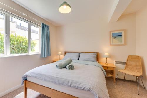 a bedroom with a bed and two windows at 3 Bed in Putsborough oc-flat11 in Croyde