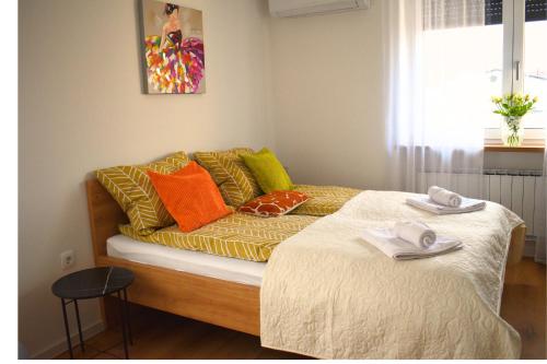 a couch with pillows on it in a room at Ahat apartment- Modern stay near center & free parking in Maribor