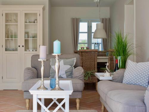 a living room with two couches and a blue candle at Ferienwohnungen Bosbuell Huus in Bosbüll