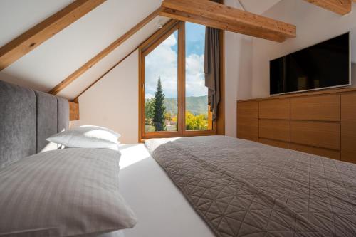 a bedroom with a bed and a large window at Ambient Resort Bled in Bled