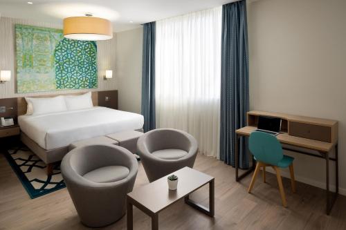 a hotel room with a bed and two chairs at ibis Jeddah City Center in Jeddah