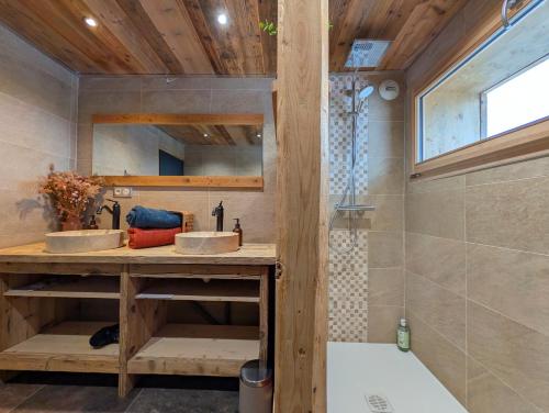 un bagno con due lavandini e una doccia di Au pré des saisons a Les Avanchers