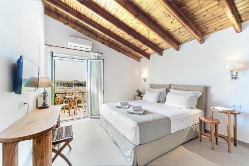 un dormitorio con cama y escritorio y balcón en Villa Eftichia Hotel Apartments & Studios, en Kontokali