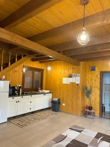 a kitchen with white cabinets and a wooden wall at Casa Favorit in Costeşti