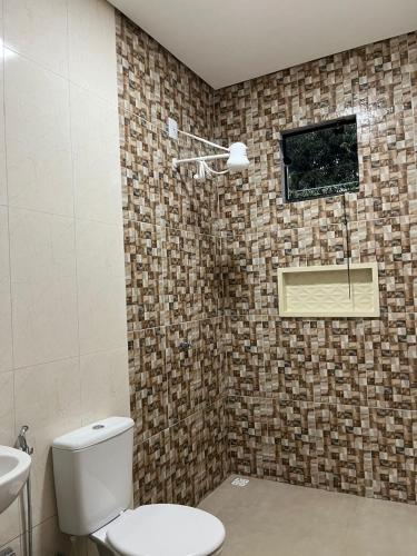 a bathroom with a toilet and a sink and a window at CasAnita in Cavalcante