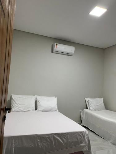 a bedroom with two beds and a air conditioner on the wall at CasAnita in Cavalcante
