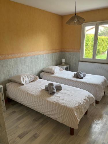 two beds in a room with two towels on them at La Villa Noyau Doux in Ampuis