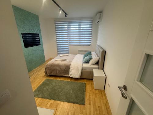 a small bedroom with a bed and a window at Apartman "Paolo" Istočno Sarajevo in Vranješ