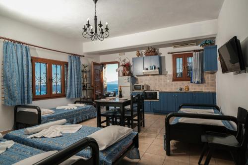 a room with two beds and a table in it at Irini Studios in Psarou