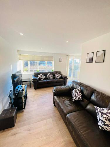 a living room with two leather couches and a television at Modern 2 Bedroom 2 Bathroom City Apartment Free Parking in Newcastle upon Tyne