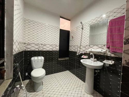 a bathroom with a toilet and a sink at Own It Hotel in Islamabad