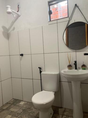 a bathroom with a toilet and a sink at Pousada Portal D'amaro in Santo Amaro