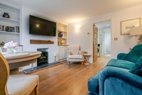 a living room with a blue couch and a fireplace at The Knutsford Cottage in Knutsford