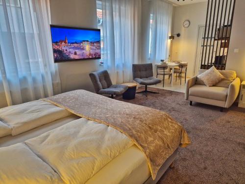 a hotel room with a bed and a tv on the wall at Apartament Strumyk in Czarnków