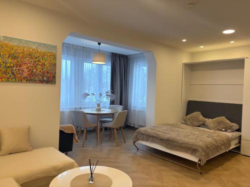 a living room with a bed and a table at Cozy city centre apartment in Telšiai