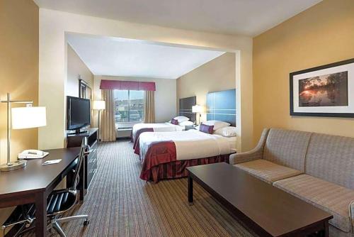 a hotel room with two beds and a couch at Hotel Willowbrook in Houston