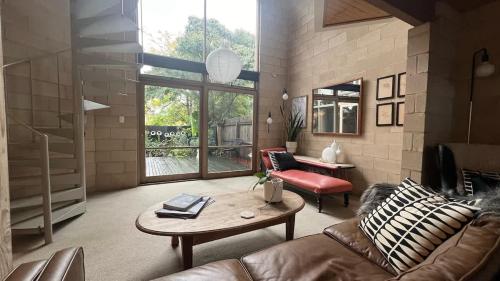 a living room with a couch and a table at Architectural Gem in Geelong in Geelong