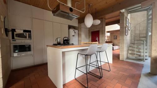 a kitchen with a bar with stools at a counter at Architectural Gem in Geelong in Geelong