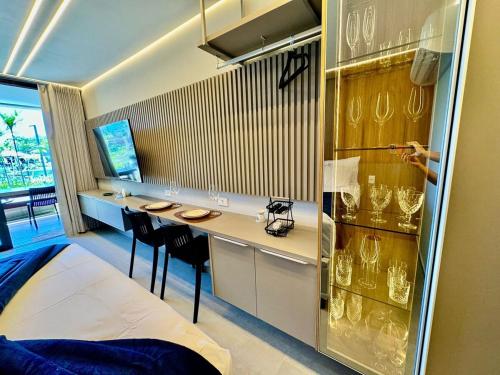 a room with a bed and a counter with glasses at Flat Lindo em Muro Alto Resort Beach Class Verano Porto de Galinhas in Porto De Galinhas