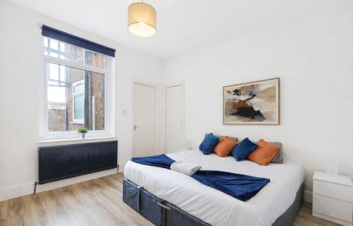 a bedroom with a large bed with blue and orange pillows at The Stockton Apartment by GR Estates in Stockton-on-Tees