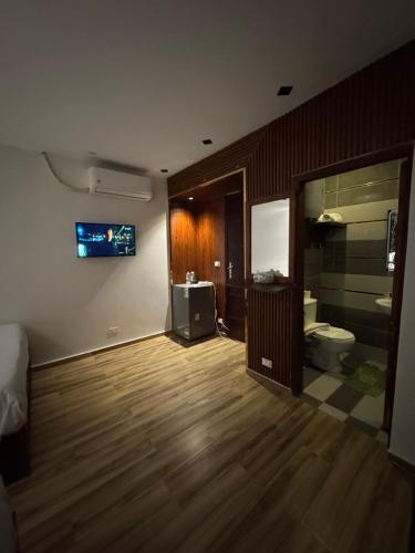 a room with a toilet and a television on a wall at Sahara Pyramids Inn in Cairo