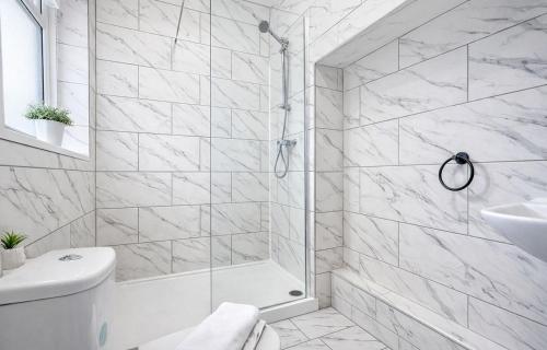 a white bathroom with a shower and a toilet at The Stockton Apartment by GR Estates in Stockton-on-Tees