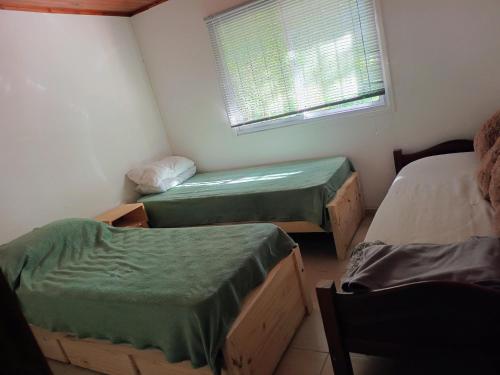 a small room with two beds and a window at Umbral del valle in Valle Hermoso