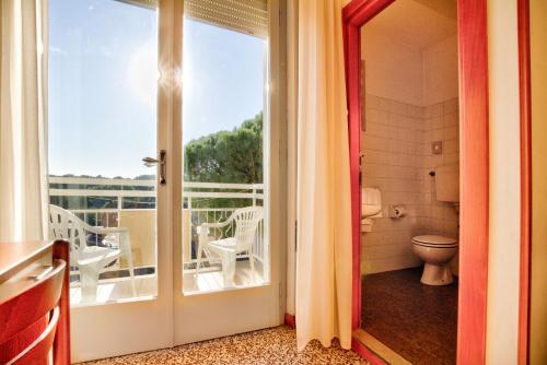 an open door to a balcony with a toilet at Hotel Happy in Milano Marittima