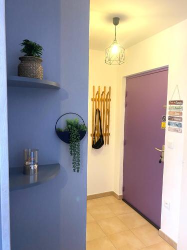 a hallway with a purple wall and a purple door at Aéroport à pied, Escale 25 in Tillé